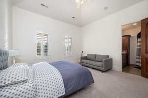 Carpeted bedroom featuring a ceiling fan and ensuite bathroom