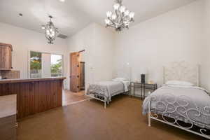 Bedroom featuring a chandelier and light colored carpet