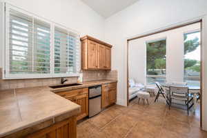 Kitchen with plenty of natural light, backsplash, tile countertops, and light tile patterned floors