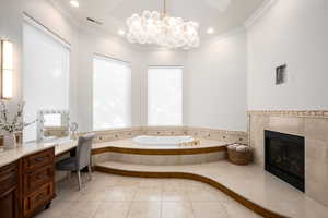 Bathroom with a bath, a tile fireplace, ornamental molding, light tile patterned flooring, and recessed lighting