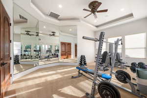 Exercise area featuring a tray ceiling, carpet, ceiling fan, and recessed lighting