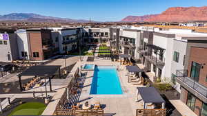 Community pool with a mountain view, a patio area, a pergola, and a residential view