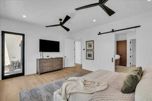 Bedroom with a barn door, light wood finished floors, recessed lighting, ceiling fan, and access to outside