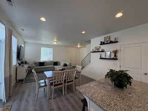 Dining area featuring dark wood finished floors, recessed lighting, and stairs