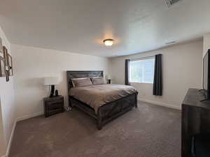 Bedroom with carpet floors and a textured ceiling