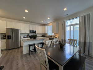 Dining room with recessed lighting and dark wood-style flooring