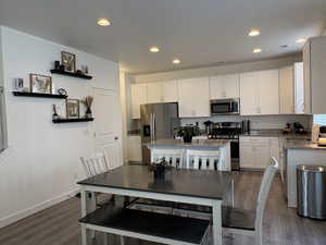 Dining area featuring dark wood finished floors and recessed lighting