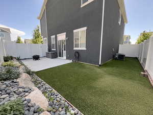 Rear view of house with a fenced backyard, a patio, and stucco siding