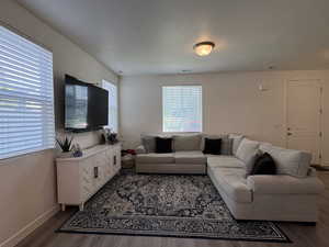Living area featuring baseboards and dark wood-style flooring