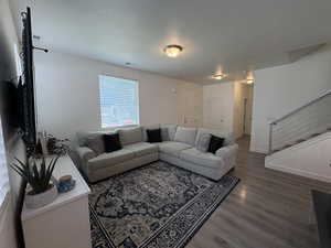 Living area with wood finished floors and stairway
