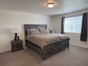 Bedroom with carpet and a textured ceiling