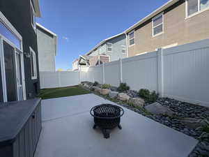 Fenced backyard featuring an outdoor fire pit, a patio, and a residential view