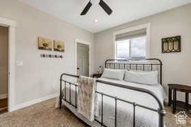 Carpeted bedroom with a ceiling fan and recessed lighting