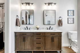 Full bathroom with toilet and double vanity