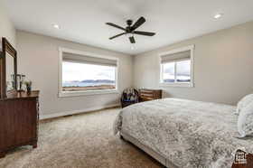 Bedroom featuring light colored carpet, a ceiling fan, and recessed lighting