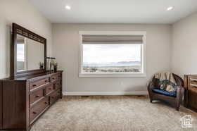 Living area with light colored carpet and recessed lighting