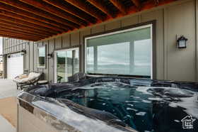 View of patio / terrace with a hot tub and an attached garage