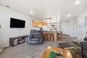 Living area with light carpet and recessed lighting