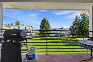 Patio / terrace with area for grilling, a residential view, and a lawn