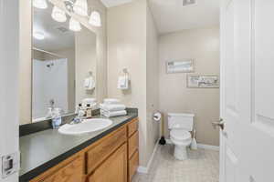 Bathroom featuring vanity, light tile patterned floors, and a shower