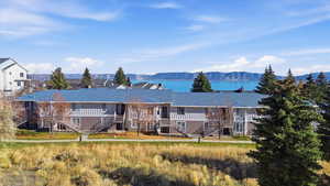 View of front of home featuring stairway, a water and mountain view, and board and batten siding