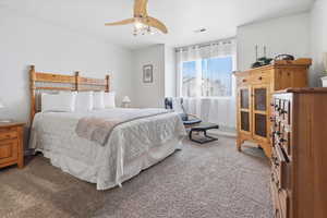 Bedroom featuring light colored carpet and a ceiling fan