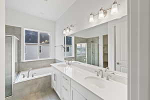 Bathroom featuring double vanity, a shower stall, a bath, a spacious closet, and light tile patterned floors
