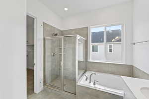 Full bath featuring a bath, vanity, a spacious closet, a shower stall, and recessed lighting
