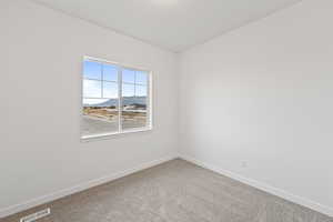 Carpeted empty room with a mountain view and baseboards
