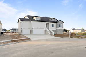 View of front of home featuring concrete driveway, a garage, board and batten siding, and a shingled roof