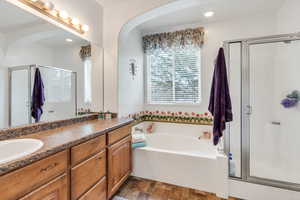 Full bathroom featuring a stall shower, vanity, a garden tub, and recessed lighting