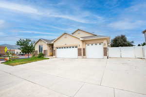 View of front of house with an attached garage, driveway, brick siding, and stucco siding