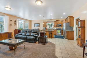 Great room area with light tile patterned floors and recessed lighting