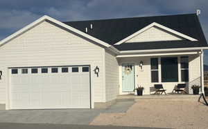 View of front of house with a porch, concrete driveway, a shingled roof, and a garage