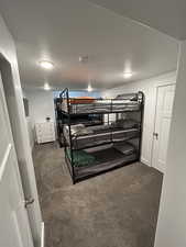 Bedroom with dark carpet and baseboards