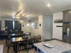 Dining space featuring a textured ceiling, light wood-style flooring, and a chandelier