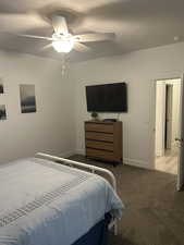 Bedroom featuring carpet floors, ceiling fan, and a textured ceiling