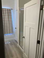 Bathroom with light wood-style floors and a shower stall