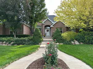 View of front of property with a front yard and brick siding