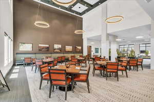 Dining room with a high ceiling and light colored carpet