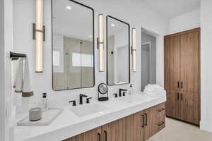 Bathroom with double vanity, a stall shower, and recessed lighting
