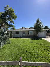 Ranch-style home with concrete driveway and an attached garage