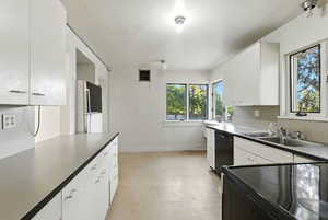 Kitchen featuring newer range and dishwasher and a clean fridge.
