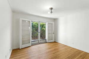 Empty room with light wood finished floors and ornamental molding