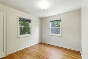 Spare room featuring light wood-style floors and baseboards