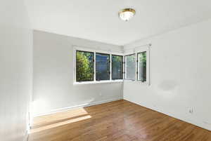 Empty room featuring wood-type flooring and baseboards
