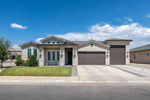 View of front of house with a garage, stucco siding, and stone siding