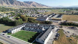 Aerial view of property and surrounding area featuring nearby suburban area and mountains