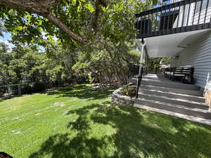 Fenced backyard with a balcony and a deck