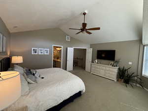 Bedroom featuring carpet, lofted ceiling, a ceiling fan, a textured ceiling, and connected bathroom